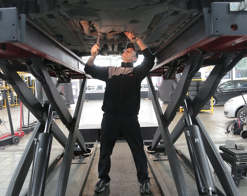 a mechanic working on a car's underchassis